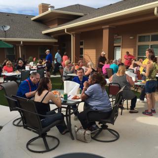 A social gathering on a patio with people enjoying each other's company outdoors.