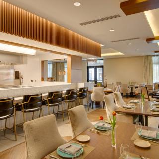A modern restaurant interior featuring a cozy dining area with elegantly set tables.