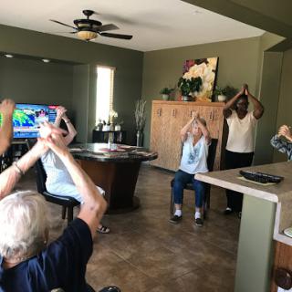Seniors engaging in a group exercise session indoors, promoting wellness and physical activity.