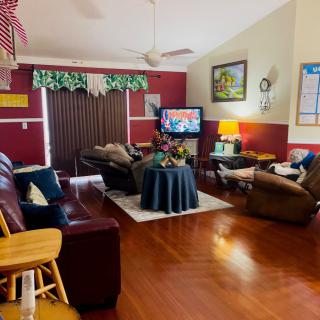Cozy living room with a television, couches, and wooden flooring.