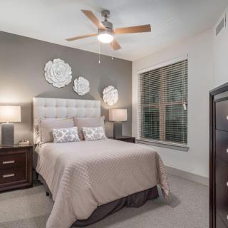 A cozy bedroom with a bed, nightstands, and a ceiling fan.