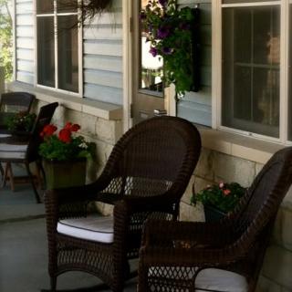 A cozy porch with wicker chairs and potted flowers.