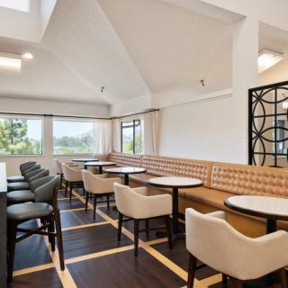 A modern dining area with natural light, featuring stylish tables and chairs.