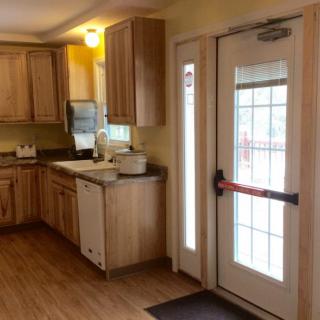 A cozy kitchen with wooden cabinets and a door to the outside.