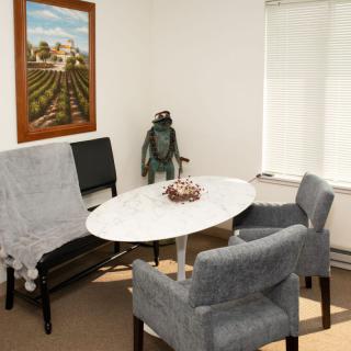 A cozy office meeting area with a round table, chairs, and decorative items.