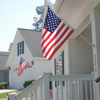 A suburban neighborhood displaying American flags on porches.