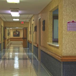 An empty hospital corridor with bright fluorescent lighting.