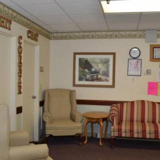 A cozy waiting room with chairs, a sofa, and wall decor.
