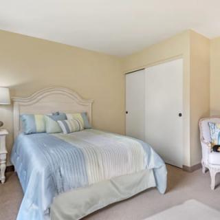 A cozy bedroom with a neatly made bed and pastel-colored decor.