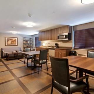 A modern kitchen and dining area with wooden tables and chairs.
