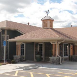 Exterior view of a building with a pitched roof and accessible parking space.