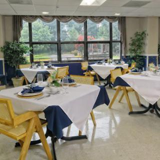 An elegantly set dining area with neatly arranged tables and chairs, ready for guests.