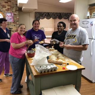 A group of people enjoying a cooking activity in the kitchen.