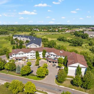 An aerial view of a residential complex surrounded by greenery and open fields.