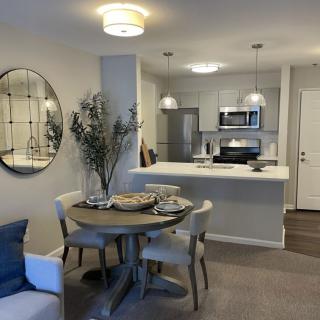 A modern open-concept living space with a cozy dining area and sleek kitchen.
