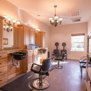 A well-lit hair salon with mirrors, chairs, and washing stations.