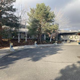 A serene view of a building surrounded by trees along a winding street.