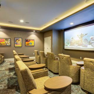 A cozy home theater room with comfortable seating and a large projector screen.