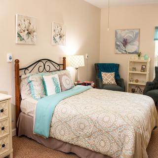 A cozy bedroom featuring a comfortable bed, elegant decor, and soft lighting.