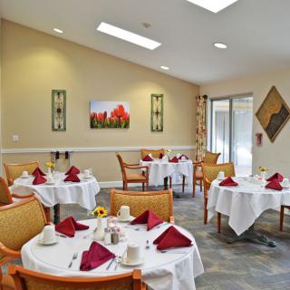 A formal dining area with neatly set tables and chairs.