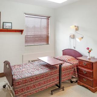 A cozy hospital room featuring two beds, designed for patient comfort and care.