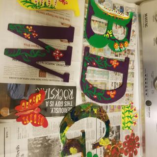 Decorated wooden letters painted with colorful flower designs.