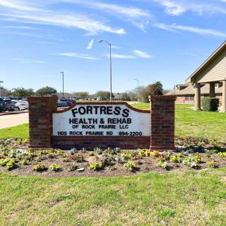 Entrance sign of Fortress Health & Rehab surrounded by a landscaped area.
