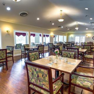 An empty dining hall with neatly arranged tables and chairs.