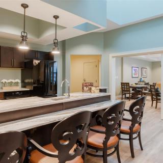 A modern kitchen and dining area with bar seating and stylish lighting.