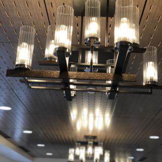 A modern chandelier with multiple cylindrical glass lights illuminating an indoor space.