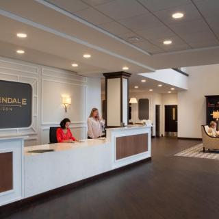 A modern hotel lobby with a reception desk and staff.