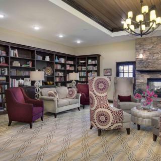 A cozy living room with bookshelves and comfortable seating arranged around a fireplace.