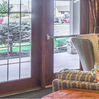 A cozy living room with a striped armchair next to large glass doors leading outside.