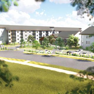 A serene view of a modern apartment complex surrounded by lush greenery and a spacious parking area.