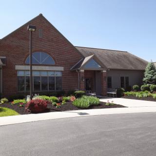 A brick building with landscaped surroundings on a sunny day.