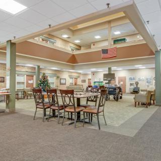 A spacious interior dining area featuring multiple tables and chairs, with ample lighting and decor.