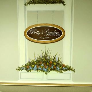 A wall sign for 'Patty's Garden' featuring a decorative flower arrangement.