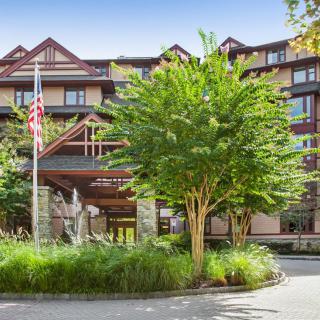 A scenic view of a hotel entrance surrounded by lush greenery.
