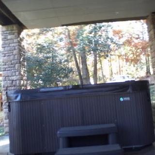 A cozy hot tub nestled in a serene outdoor setting, surrounded by autumn foliage.