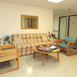 A cozy waiting room with a sofa, chairs, and a coffee table.