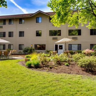 A well-maintained apartment building surrounded by landscaped gardens and greenery.