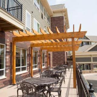 An inviting outdoor patio area featuring a wooden pergola and stylish furniture.