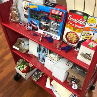 A red shelf displaying a variety of items including toys, food, and decorative pieces.
