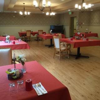 A restaurant dining area with red tablecloths and chandeliers.