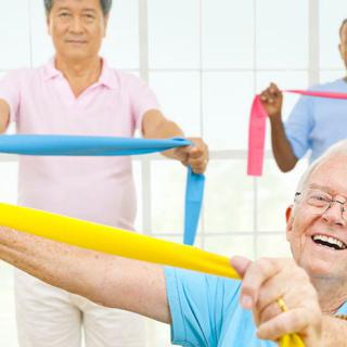 A group of seniors engaging in a fitness class using resistance bands, promoting a healthy and active lifestyle.