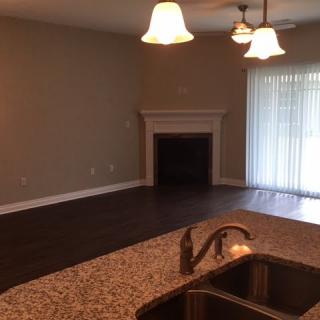 Open living space with a fireplace and kitchen view.