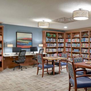 A cozy library space with bookshelves, a reading area, and computer stations.