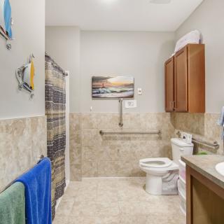 A modern bathroom with a toilet, sink, shower, and tiled walls.