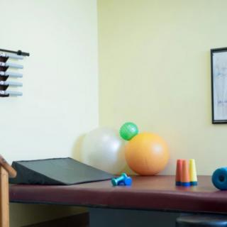 A physical therapy room equipped with exercise balls and various rehabilitation tools.