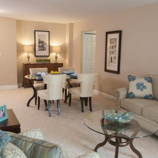 A cozy living room with an adjoining dining area, featuring elegant furniture and tasteful decor.